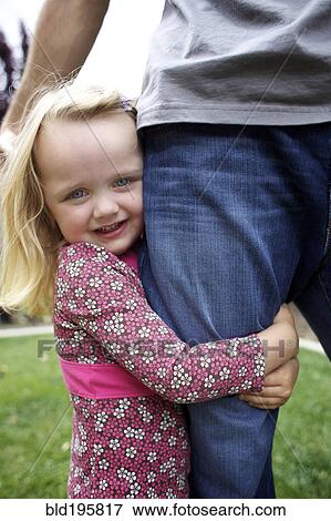 Caucasian girl hugging father's leg View Large Photo Image Stock Photo - Caucasian girl hugging father's leg. Fotosearch