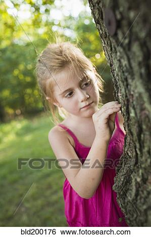Stock Photograph - Caucasian girl looking at tree. Fotosearch