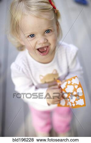 Stock Photo - Caucasian girl playing with stickers. Fotosearch