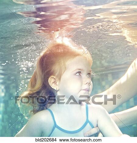 Picture - Caucasian girl swimming under water. Fotosearch