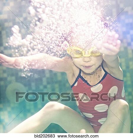 Stock Image - Caucasian girl swimming under water. Fotosearch
