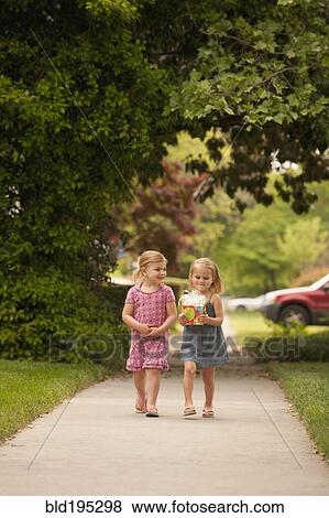 Caucasian girl walking on sidewalk with gift View Large Photo Image Stock Photo - Caucasian girl walking on sidewalk with gift. Fotosearch