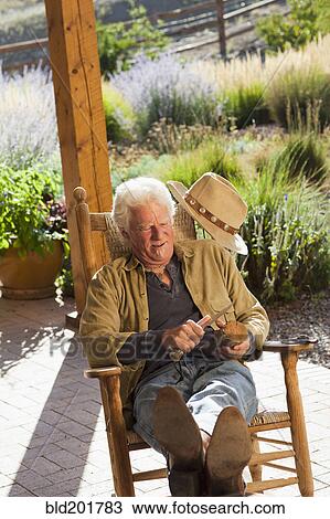 Stock Image - Caucasian man carving wood. Fotosearch