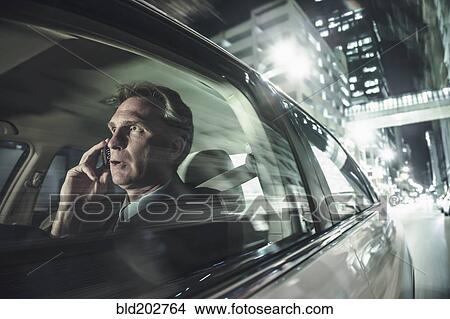 Caucasian man driving and talking on cell phone View Large Photo Image Picture - Caucasian man driving and talking on cell phone. Fotosearch
