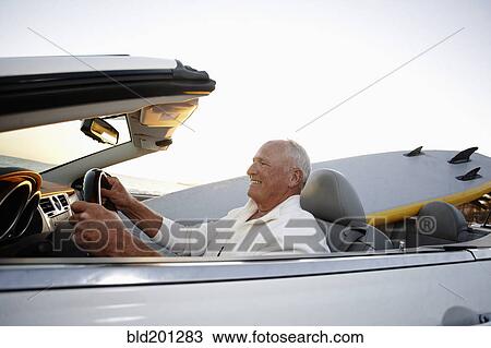 Stock Image - Caucasian man driving convertible. Fotosearch
