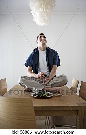 Stock Photography - Caucasian man having dinner sitting on table. Fotosearch