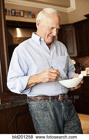 Stock Photo - Caucasian man holding bowl. Fotosearch