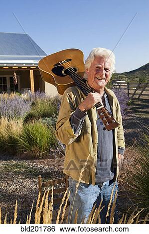 Stock Photograph - Caucasian man holding guitar. Fotosearch