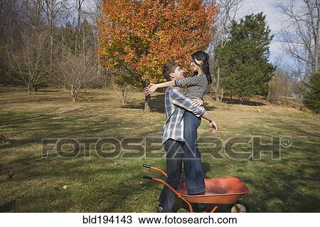 Caucasian man hugging girlfriend in yard View Large Photo Image Stock Image - Caucasian man hugging girlfriend in yard. Fotosearch