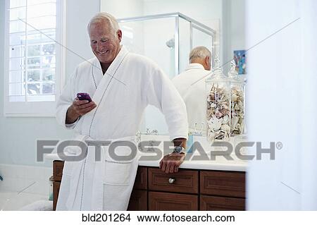 Caucasian man in robe using cell phone View Large Photo Image Picture - Caucasian man in robe using cell phone. Fotosearch