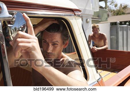 Stock Photo - Caucasian man in truck fixing hair. Fotosearch