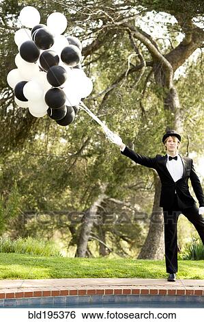 Caucasian man in tuxedo holding bunch of balloons View Large Photo Image Stock Photograph - Caucasian man in tuxedo holding bunch of balloons. Fotosearch
