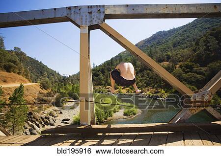 Caucasian man jumping into river from bridge View Large Photo Image Stock Photograph - Caucasian man jumping into river from bridge. Fotosearch