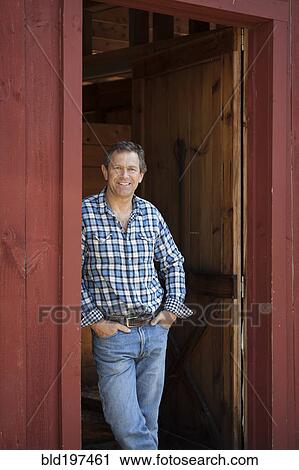 Stock Image - Caucasian man leaning in doorway. Fotosearch
