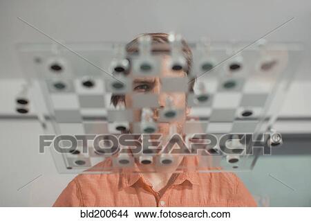 Picture - Caucasian man playing chess. Fotosearch