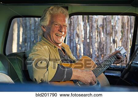 Caucasian man playing guitar in truck View Large Photo Image Stock Image - Caucasian man playing guitar in truck. Fotosearch