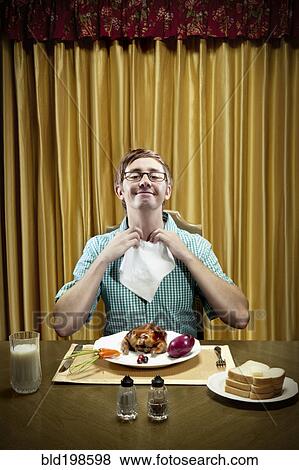 Stock Photo - Caucasian man preparing to eat dinner. Fotosearch