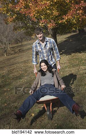 Caucasian man pushing wife in wheelbarrow View Large Photo Image Stock Image - Caucasian man pushing wife in wheelbarrow. Fotosearch