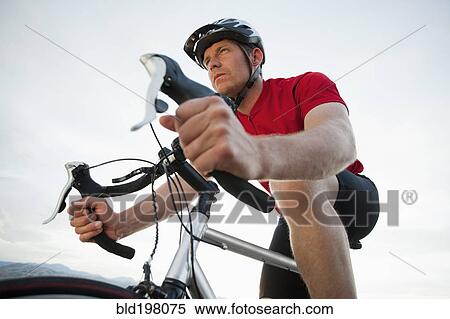 Stock Photography - Caucasian man riding bicycle. Fotosearch
