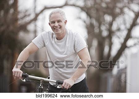 Picture - Caucasian man riding bike. Fotosearch
