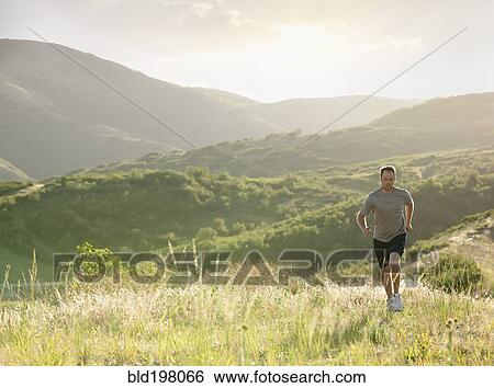 Caucasian man running on remote hill View Large Photo Image Stock Photograph - Caucasian man running on remote hill. Fotosearch