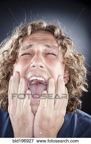 Caucasian man shouting with head in hands View Large Photo Image Stock Photo - Caucasian man shouting with head in hands. Fotosearch