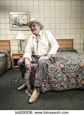 Stock Photograph - Caucasian man sitting in hotel room. Fotosearch