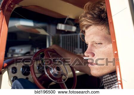 Stock Image - Caucasian man sitting in truck. Fotosearch