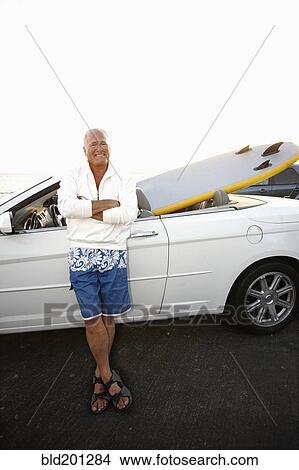 Caucasian man standing with car and paddleboard View Large Photo Image Picture - Caucasian man standing with car and paddleboard. Fotosearch