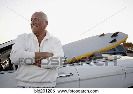 Caucasian man standing with car and paddleboard View Large Photo Image Stock Photography - Caucasian man standing with car and paddleboard. Fotosearch