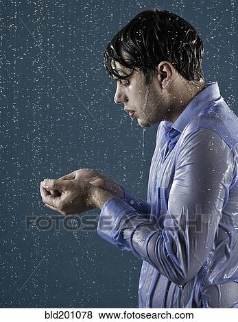 Stock Photo - Caucasian man taking a shower in clothing. Fotosearch