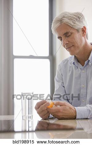 Stock Photography - Caucasian man taking medicine. Fotosearch
