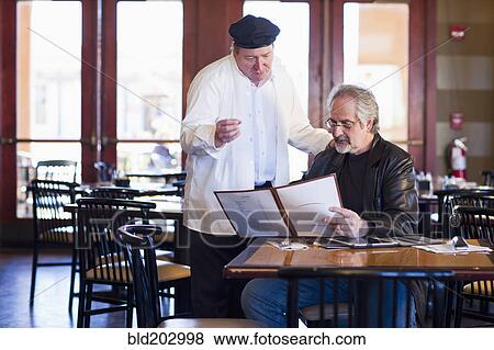 Stock Photo - Caucasian man talking to chef in restaurant. Fotosearch