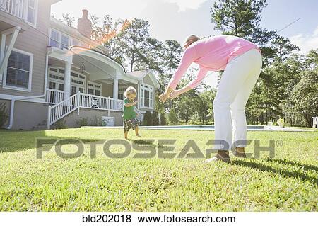 Stock Photo - Caucasian mother and son playing in backyard. Fotosearch
