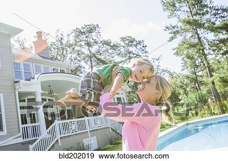 Caucasian mother and son playing in backyard View Large Photo Image Stock Photo - Caucasian mother and son playing in backyard. Fotosearch