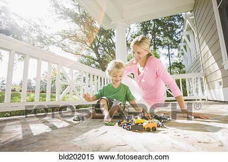 Stock Photography - Caucasian mother and son playing with toys on porch. Fotosearch