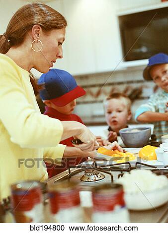 Stock Image - Caucasian mother and sons preparing food. Fotosearch