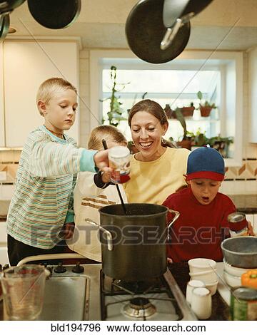 Stock Photograph - Caucasian mother and sons preparing food. Fotosearch