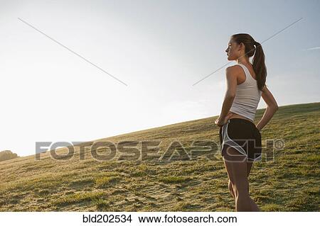 Picture - Caucasian runner standing in field. Fotosearch