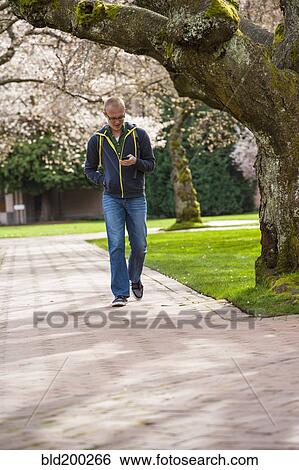 Caucasian student using cell phone on campus View Large Photo Image Stock Photograph - Caucasian student using cell phone on campus. Fotosearch