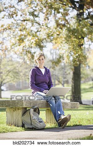 Picture - Caucasian student using laptop on campus. Fotosearch