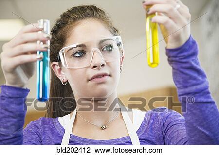 Stock Image - Caucasian student working with chemicals in classroom. Fotosearch