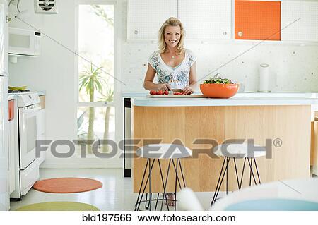 Stock Photograph - Caucasian woman cooking in kitchen. Fotosearch