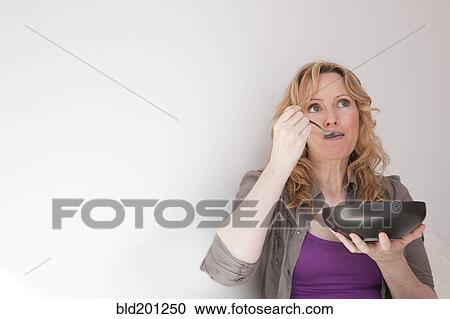 Stock Image - Caucasian woman eating soup. Fotosearch