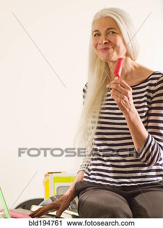 Stock Image - Caucasian woman enjoying popsicle. Fotosearch