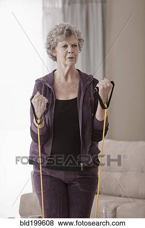Stock Photo - Caucasian woman exercising in living room. Fotosearch