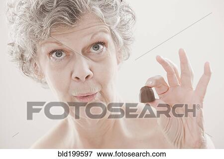 Stock Photo - Caucasian woman holding chocolate. Fotosearch