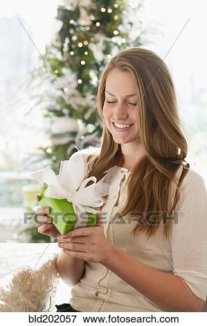 Stock Photo - Caucasian woman holding Christmas gift. Fotosearch