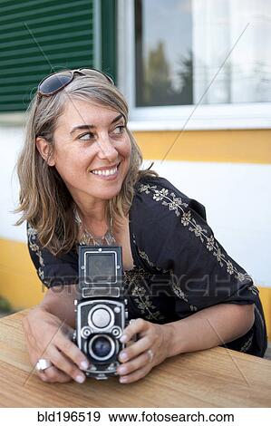 Caucasian woman holding old-fashioned camera View Large Photo Image Stock Photo - Caucasian woman holding old-fashioned camera. Fotosearch