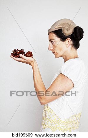 Caucasian woman holding pinecones View Large Photo Image Stock Photo - Caucasian woman holding pinecones. Fotosearch